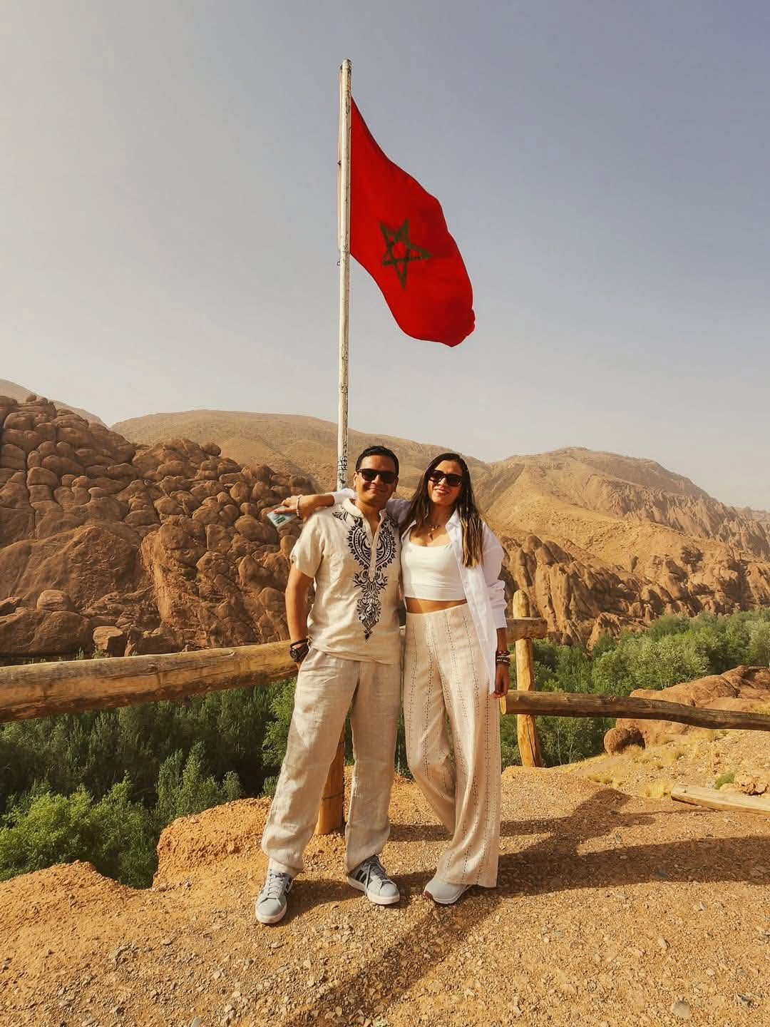 Youssef local guide leading tourists on camelback through Dades Valley at sunset Morocco