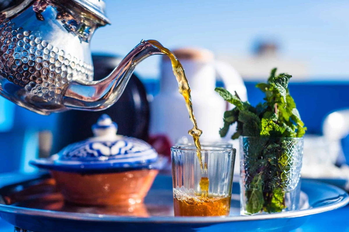 Moroccan mint tea being poured from height into small glasses